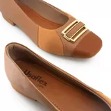Zapato bajo color marrón, de cuero, con puntera redondeada y detalle de hebilla dorada.