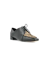 Zapato de cuero negro con cordones, de estilo masculino y diseño vanguardista.