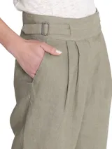 Pantalón de lino color verde, de tiro alto y pierna recta, con cierre cruzado y hebillas en los costados.