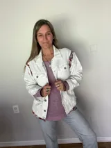 Campera de jean oversize, color rojo desgastado, con aplicaciones de tapicería multicolor de estilo étnico en hombros y ruedo, y terminaciones desflecadas.