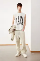 Musculosa blanca de algodón con cuello redondo y sisas sin rematar. Estampado negro con la palabra 'L.A.C.A' en el frente. Corte holgado.