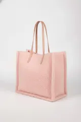 Cartera tipo tote bag color rosado, con textura de borrego y asas de cuero sintético en tono nude.