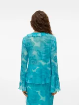 Camisa celeste con estampado de flores, cuello en V, cierre de cordón y volantes en los puños.