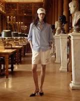 Camisa oversize celeste y blanca a rayas verticales, de popelina 100% algodón, con cuello clásico, bolsillo en el pecho bordado y puños abotonados.