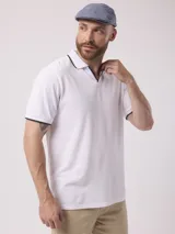 Remera blanca de manga corta con cuello polo y ribete negro en cuello y mangas.