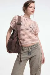 Top negro calado de tejido de punto con cuello alto y mangas cortas.