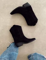 Bota corta de gamuza negra con bordados en hilo negro en la caña y puntera. Taco cuadrado y bajo.