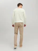 Sweater de punto color crudo, de manga larga y cuello redondo.