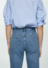 Pantalón de jean celeste, de corte mom-fit, tiro alto, con cinco bolsillos y cierre de cremallera y botón.