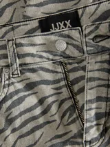 Pantalón de pierna ancha con estampado de cebra, tiro alto, cierre con cremallera y múltiples bolsillos.