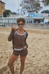 Musculosa de punto acanalado color celeste, con ribete marrón en el cuello y las sisas, y un pequeño bordado de fresa en el pecho.