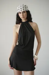 Vestido corto negro de algodón con cuello halter y faja en la cintura que se ata detrás del cuello.
