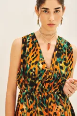 Vestido corto con estampado animal print en tonos naranja, negro y verde. Tiene escote en V, cintura elastizada y bolsillos laterales.