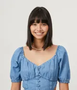Vestido midi de jean celeste con escote en V, mangas cortas abullonadas, botones forrados en el frente, abertura frontal y corte en la cintura.