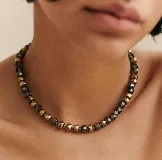 Collar corto de cuentas facetadas en tonos dorados y grises.