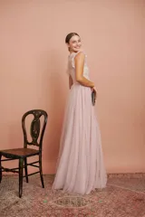 Vestido largo de fiesta color rosado con lunares blancos. Tiene cuerpo de micro tul bordado con volados en los hombros y falda de tul con forro. Incluye cinturón de raso al tono.