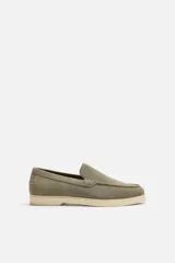 Mocasín casual de hombre color verde oliva, fabricado en cuero con acabado serraje, corte liso con detalle de bordón, horma redonda y suela a contraste color crema.