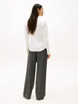 Camisa blanca de piqué de algodón elástico, corte slim, con cuello camisero, cierre de botones, puños con botón y logo de Tommy Hilfiger bordado en el pecho.