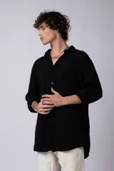 Camisa blanca de lino con cuello clásico, manga larga con puños abotonados y corte holgado. 