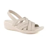 Sandalia casual Skechers Arya True Calling color beige, con tiras elásticas cruzadas en el empeine y tira trasera en el talón. Cuenta con plantilla acolchada Luxe Foam® y tacón de cuña de 1 1/2 pulgada.