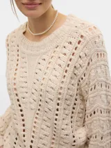 Sweater color crema tejido con cuello redondo y manga larga.