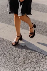 Sandalias de tacón color beige con puntera cuadrada, tiras doradas en el empeine y tobillo, y taco cuadrado.