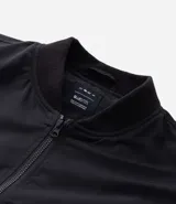 Campera bomber marrón de poliéster con cuello alto y cierre de cremallera. Puños y cintura elastizados.