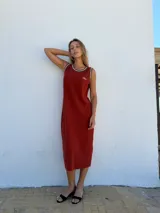 Vestido midi de punto acanalado color ladrillo, corte recto y sin mangas, con cuello redondo ribeteado en blanco y logo bordado en el pecho.