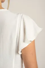 Blusa blanca con escote en V, mangas cortas con volados y cierre frontal con botones.