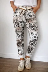 Pantalón de mujer con estampado animal print y detalles florales en blanco y negro. Incluye un cinturón de tela a juego.