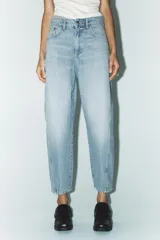 Pantalón de jean celeste de corte amplio, con tiro medio, cinco bolsillos y costuras torcidas.