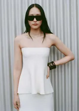 Top bandeau negro de punto fino con corte peplum.