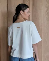 Remera negra con cuello redondo y mangas cortas, con detalle de pespuntes blancos en cuello, mangas, bolsillos frontales y ruedo.