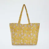 Bolso shopper acolchado amarillo con estampado floral en tonos beige.