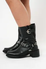 Bota negra con detalle de hebilla y apliques de studs en el tobillo, de tacón bajo.