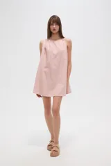 Vestido corto color rosa pálido con rayas verticales rojas, sin mangas, de corte ancho y cuello recto.