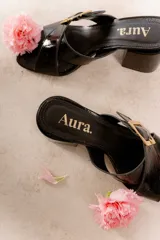 Sandalia tipo zueco de charol rojo con hebilla dorada y taco cuadrado.