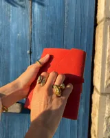 Anillo de diseño orgánico y macizo, realizado artesanalmente en bronce. Presenta una estructura abierta con dos piezas de forma irregular y textura rugosa.