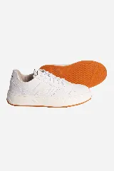 Zapatillas urbanas de cuero color blanco con suela de goma color caramelo y logo en etiqueta de cuero en la lengüeta.