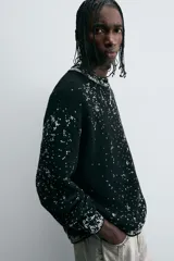 Sweater negro con cuello redondo y manga larga, tejido con diseño geométrico jacquard en blanco.