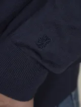 Sweater de punto color beige claro, de corte clásico y cuello redondo.