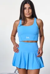 Conjunto deportivo celeste compuesto por top corto con breteles anchos y falda corta tableada.