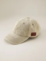 Gorra de gabardina color gris oscuro con visera curva y etiqueta con logo de la marca en el lateral.