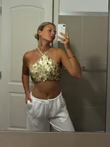 Top dorado con lentejuelas, estilo halter, con tiras regulables en cuello y espalda.