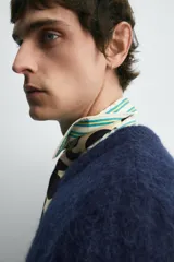 Cárdigan azul marino de manga corta tejido en hilatura con lana y alpaca, de textura suave. Tiene cuello redondo, rib en los bordes y cierre frontal con botones. Edición especial Harry Lambert for Zara x Disney.