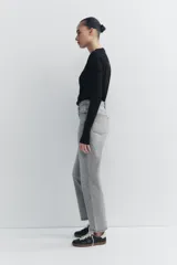 Pantalón de jean gris de tiro alto, corte mom fit, con trabillas y cinco bolsillos. Cierre frontal con cremallera y botón metálico.