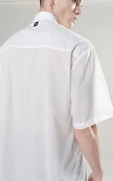 Camisa blanca de manga corta con calce oversize y canesú en la espalda.