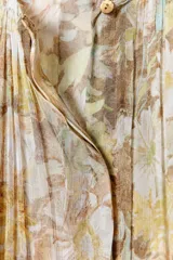Vestido largo de viscosa con estampado floral, escote en pico, manga tipo capa con aberturas y bajo asimétrico.