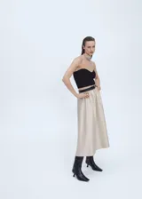 Falda midi color beige, de tejido satinado y corte evasé.