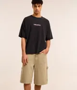 Bermuda masculina color beige, corte baggy relaxed, confeccionada en sarga lavada de algodón. Posee cintura con trabilla, cierre tradicional y bolsillo carpintero.